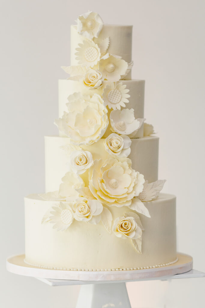 A beautiful 4 tiered wedding cake with gorgeous flower accents. 