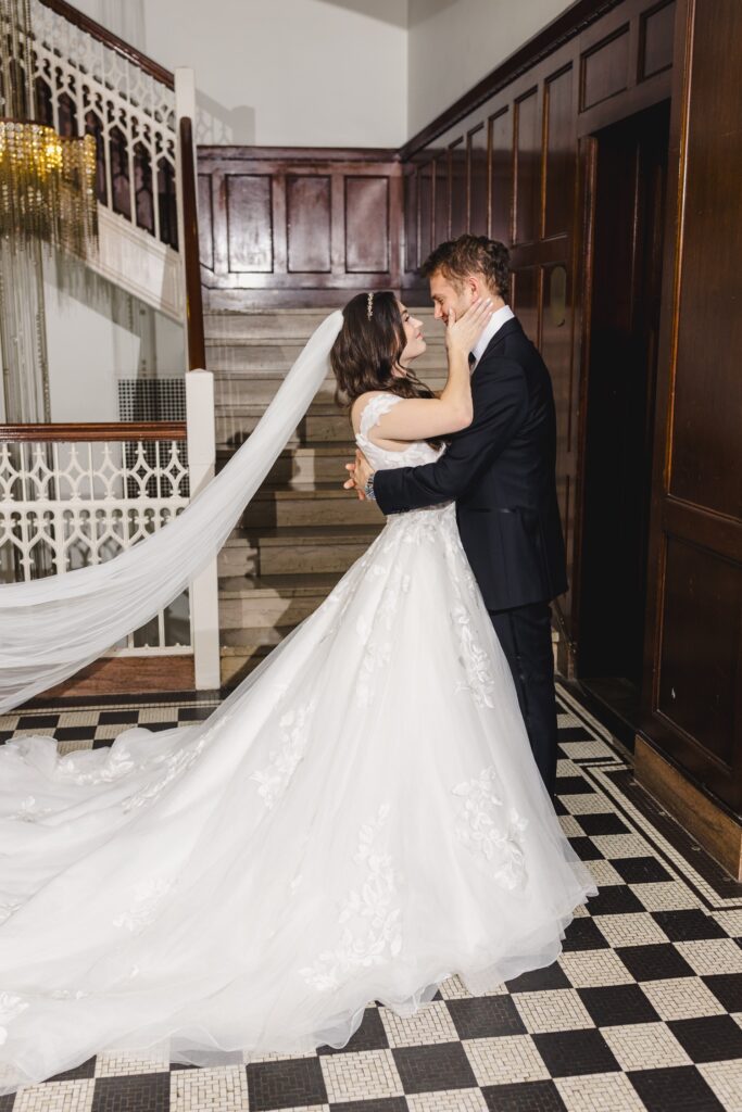 bride and groom posing at the historic staircase in Hotel Kansas City
