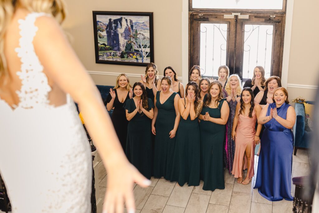 The bride doing a first look with all of her bridesmaids before her wedding at Avent Orangery.