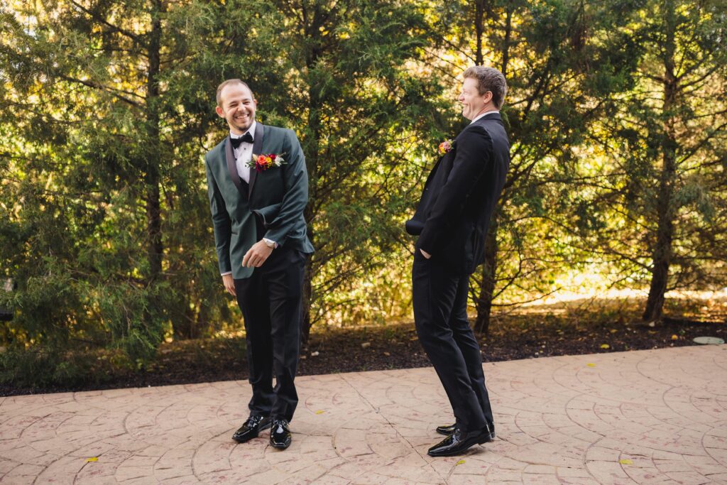 Groom and best man laughing at a first look joke.