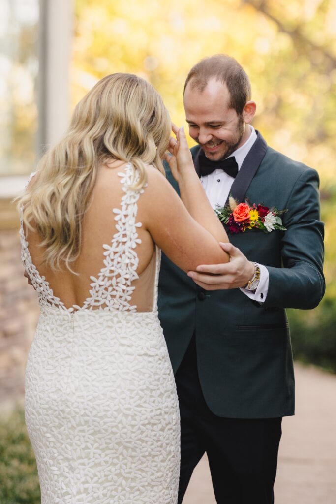 Groom taking in his brides wedding dress during their first look.