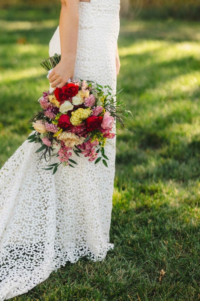 A detail shot of a wedding dress and bridal bouquet.