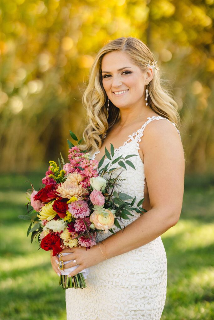 Close up of bride smiling and holding her wedding florals during her bridal portraits. 