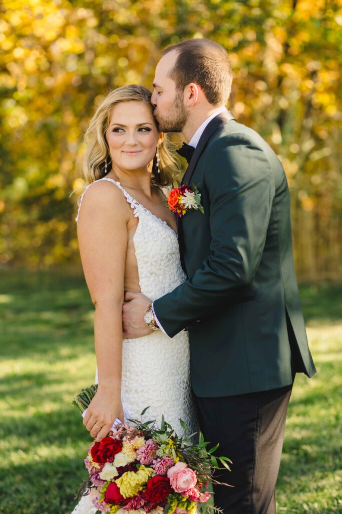 Husband kissing his wife's head during their Kansas City wedding photoshoot.