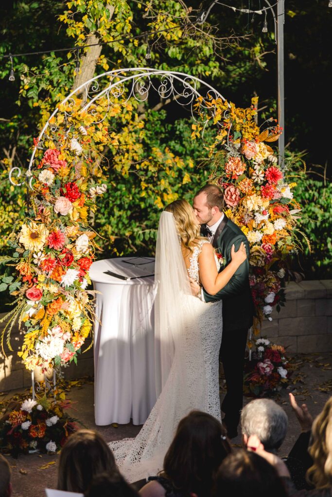 Husband and wife kissing as they tie the knot.