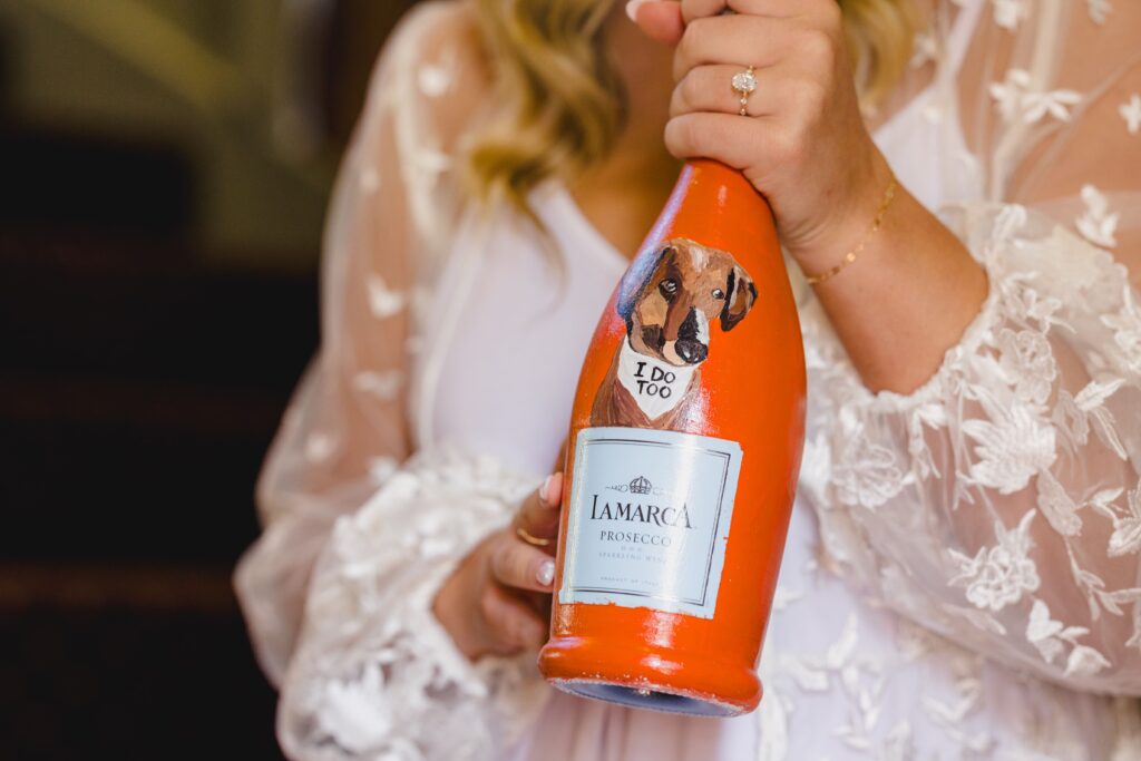 The bride holding a custom bottle of champagne for their wedding. 