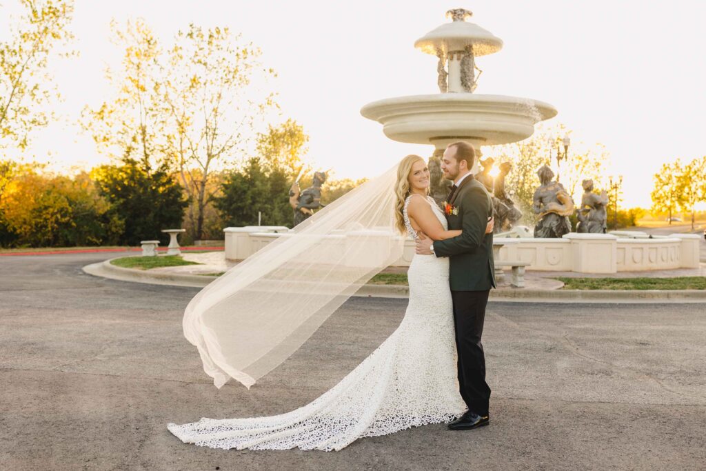 A wedding portrait at Avent Orangery taken by a Kansas City Wedding Photographer. The bride's veil is flowing in the air at golden hour.