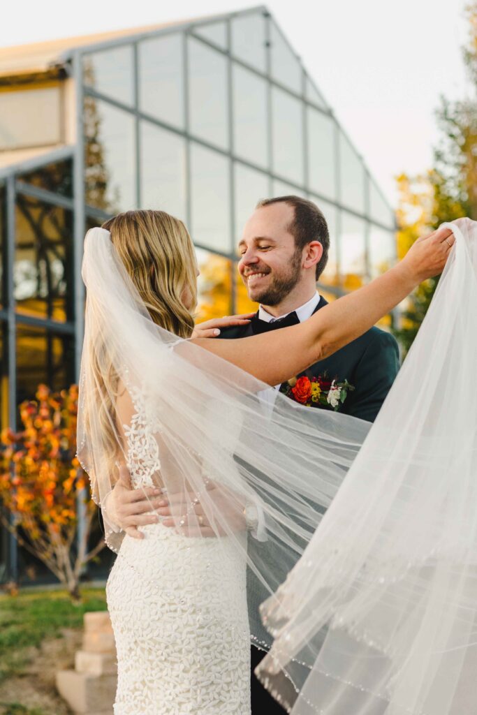 The bride wrapping her veil around the groom during their golden hour wedding portraits. 