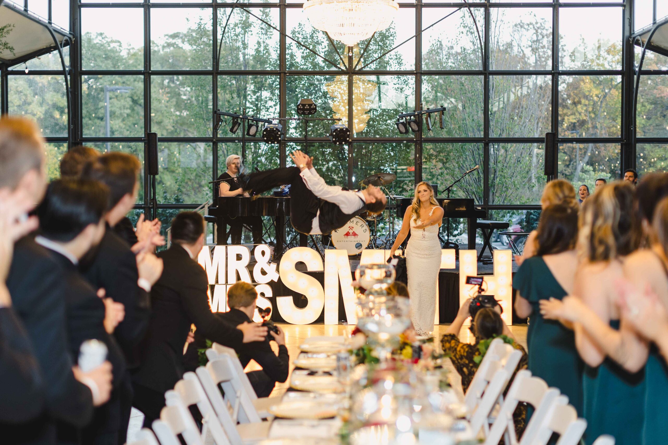 Groom doing a backflip as they entered their wedding reception, captured by their Kansas City wedding photographer. 