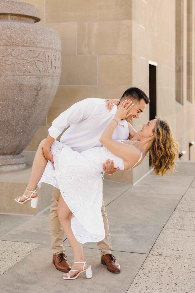 Man dipping his fiancee and smiling.