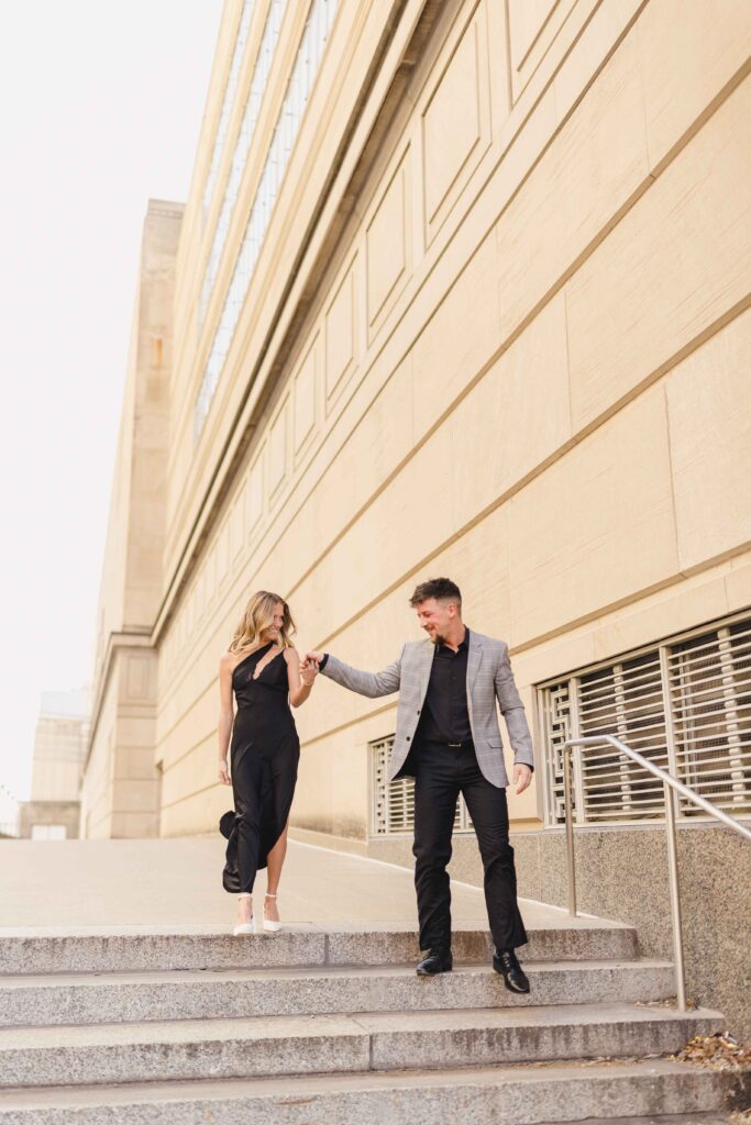 Engaged couple walking down steps during a luxury photo session.