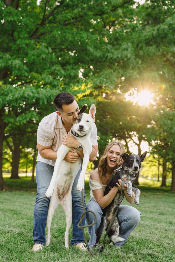 Couple holding their dogs and smiling during their engagement photoshoot. 