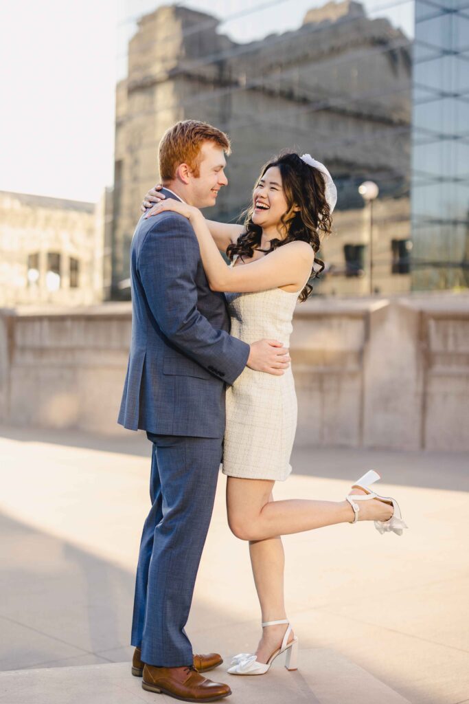 A couple standing on a bench for a fun engagement photoshoot.