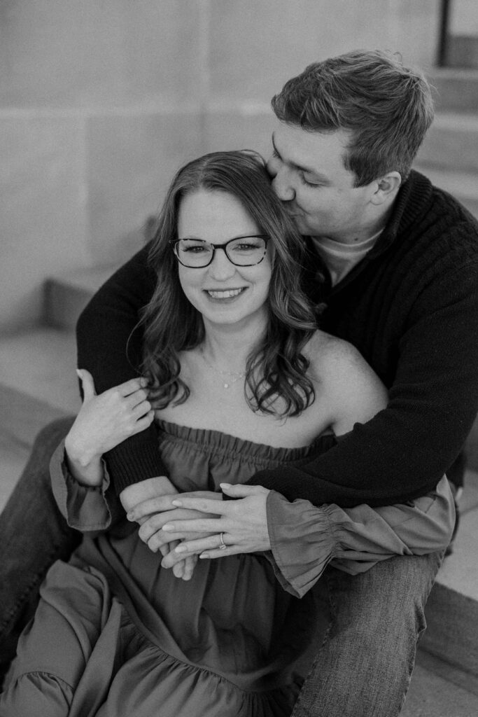 Couple sitting on steps and holding each other.