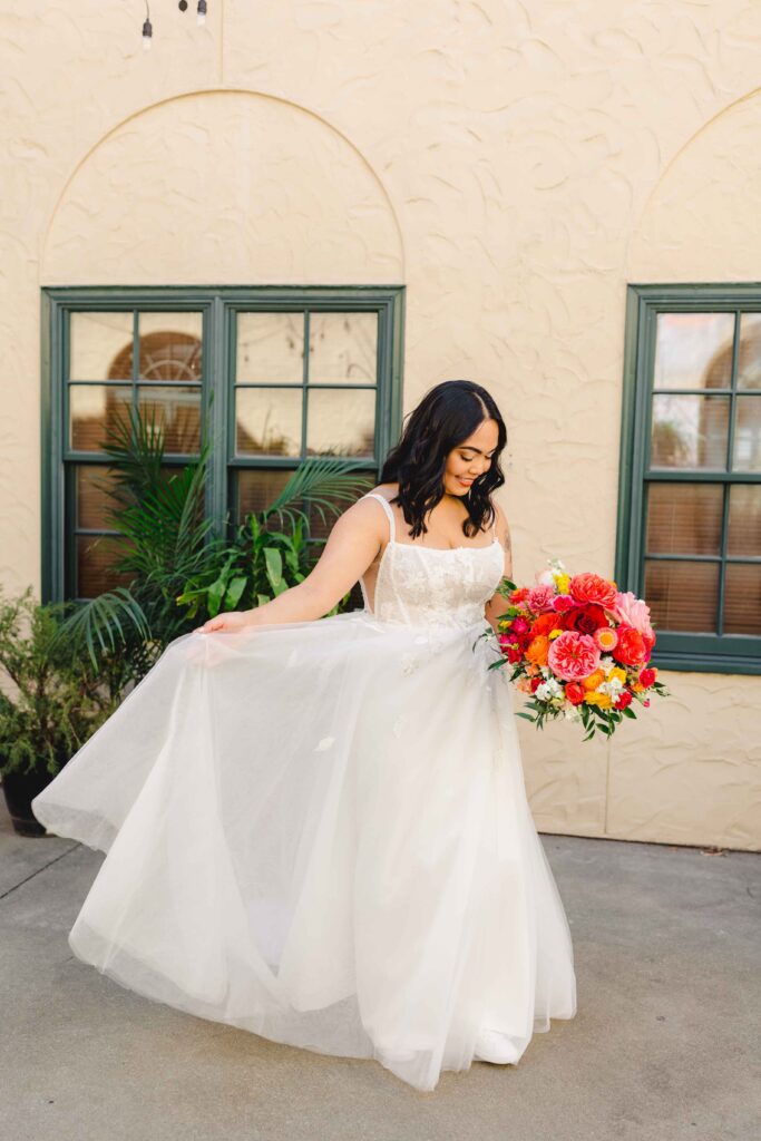 Bride holding her bridal bouquet and wedding gown.