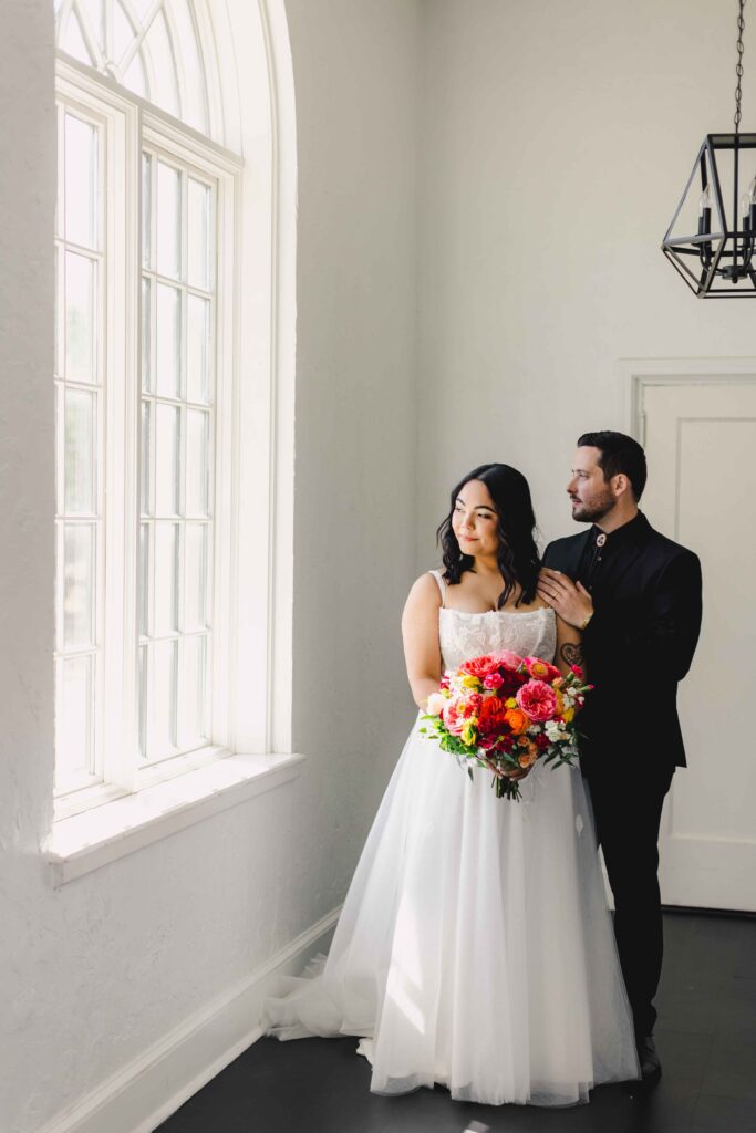 Kansas City wedding venues featuring couple portraits looking out the window at La Villa.