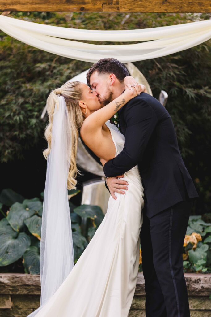 Bride and groom kissing after saying "I do" captured by a Kansas City Photographer.