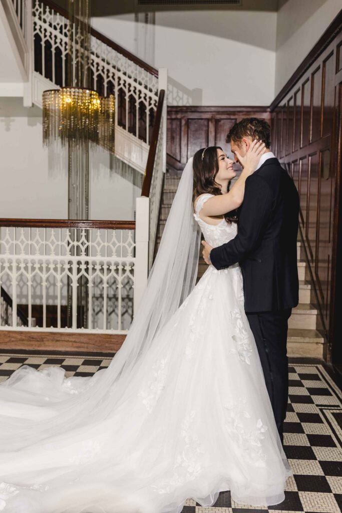 Couple smiling and holding each other during their wedding portraits at Hotel Kansas City.