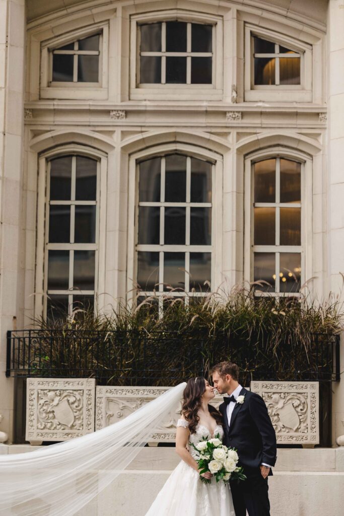 Wedding portraits with the brides veil flowing in the wind taken by a Kansas City Photographer.