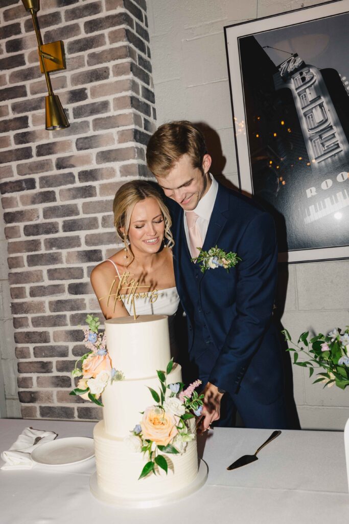 Bride and groom cutting cake at their wedding reception.