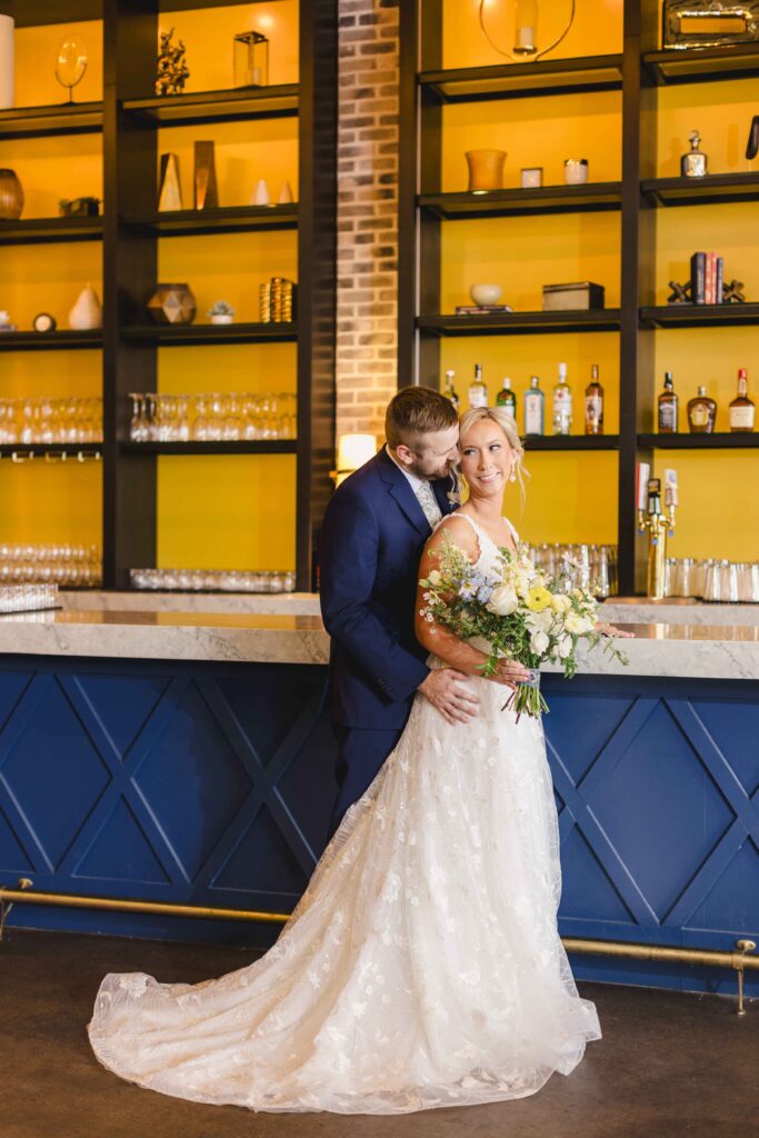 Bride and groom posing at the bar at The Austin.