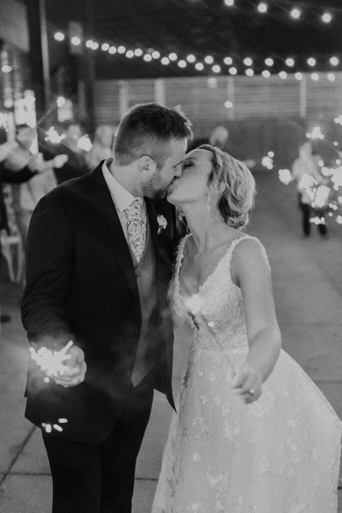 Bride and groom kissing while holding sparklers for their wedding exit at another great Kansas City wedding venues.