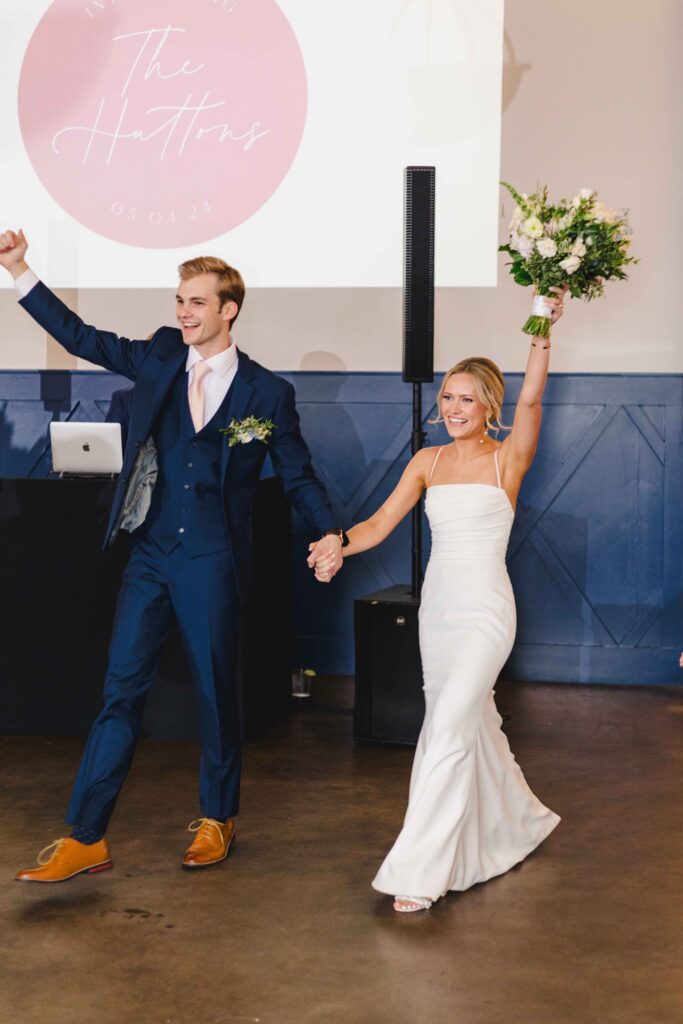 Newlyweds entering their reception at The Austin with their hands in the air enjoying their Kansas City wedding venues.