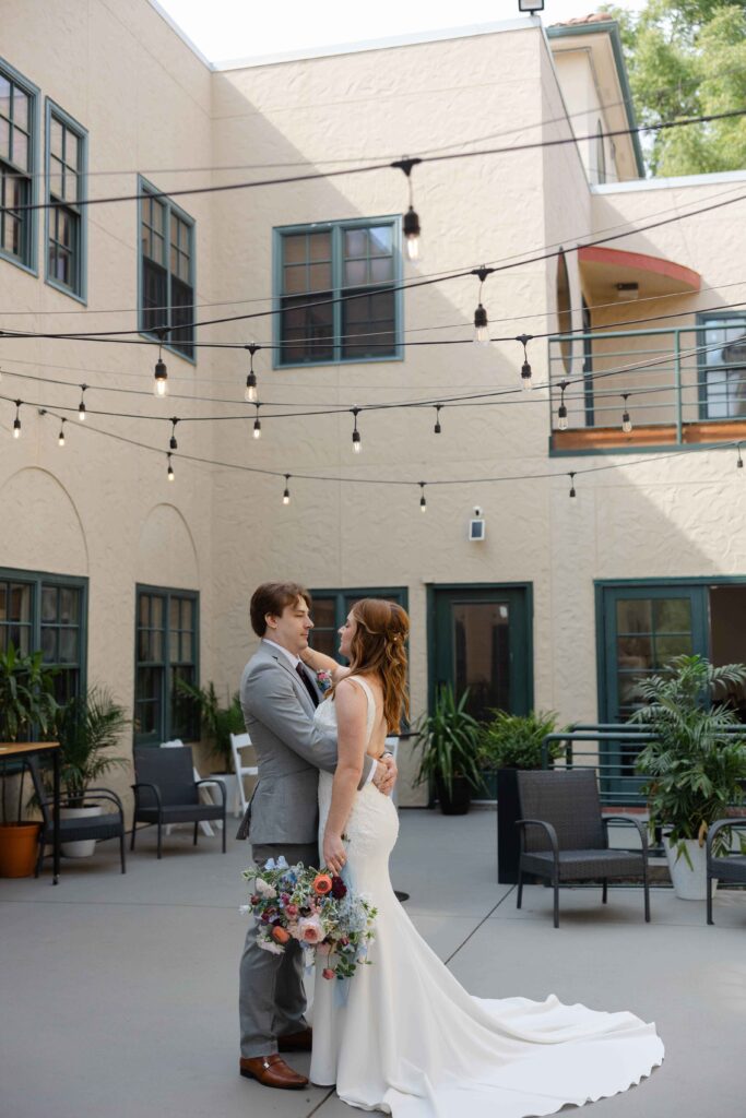 Kansas City Photographer photoshoot of a bride and groom holding each other in a courtyard.