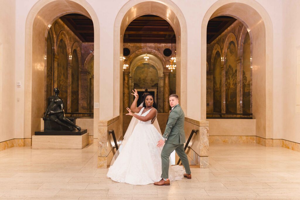 Bride and groom doing a funny pose at their Nelson Atkins wedding.