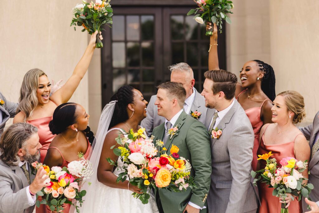 Bridal party cheering at the newlyweds. 