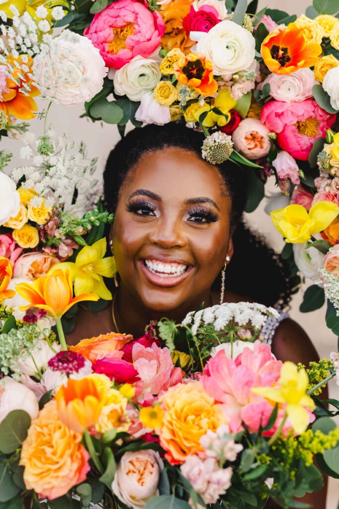 Bride surrounded by vibrant bouquets. 