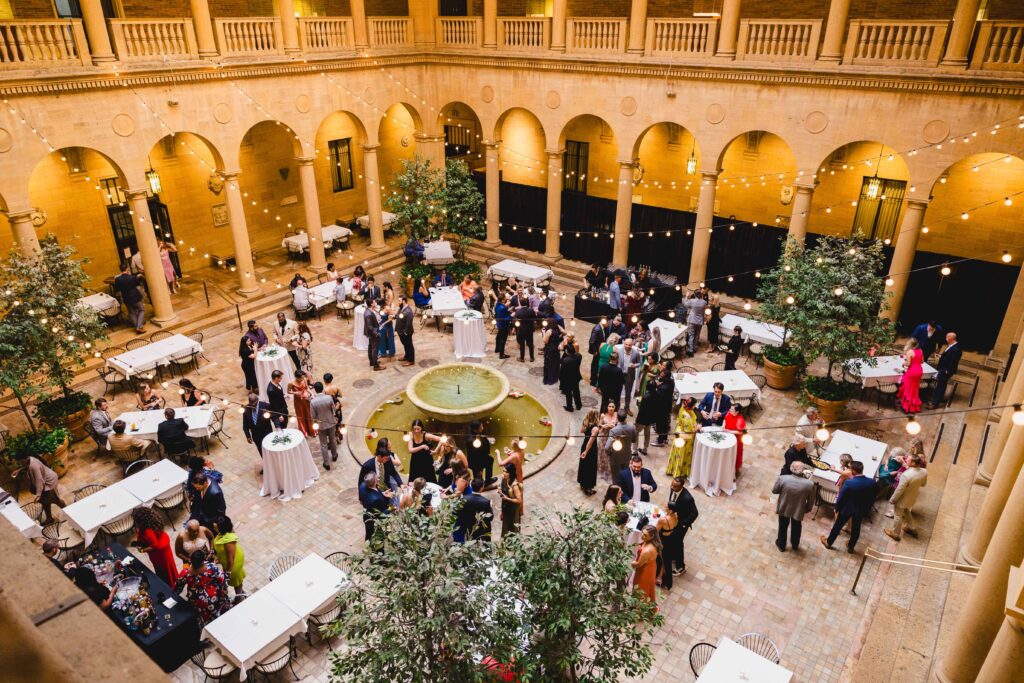 Cocktail hour at the Nelson Atkins wedding with string lights and guests mingling. 