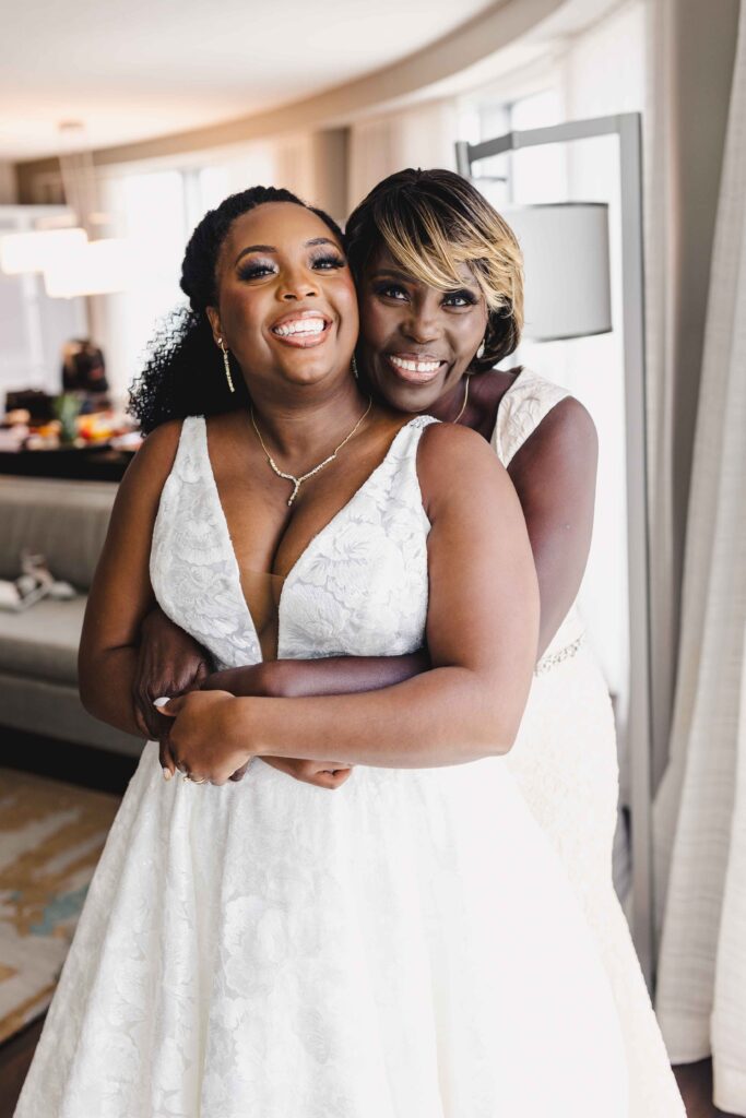 Bride and her mother hugging while getting ready.