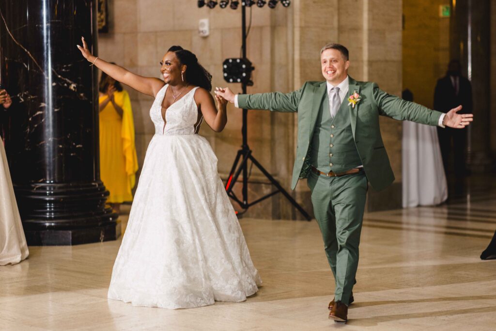 Newlyweds walking into their wedding reception at their Nelson Atkins wedding.