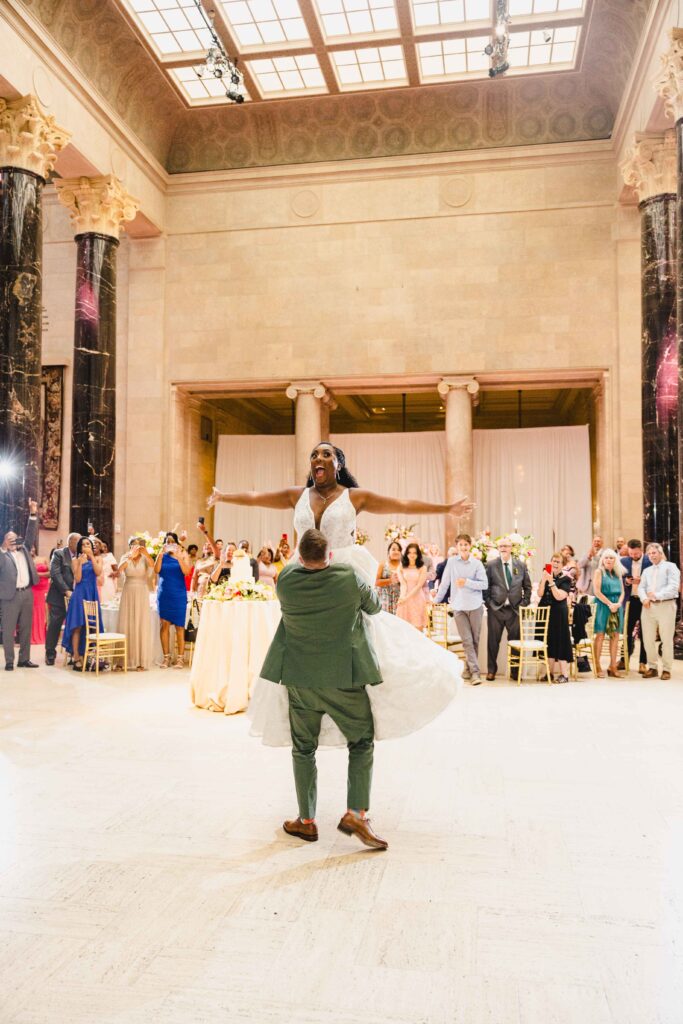 Groom picking his wife up during their first dance.