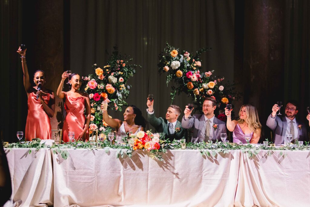 Bridal party raising their glasses after a toast at their Kansas City MO wedding venue.