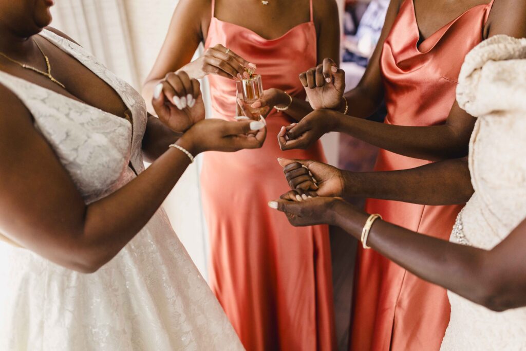 Bride and bridesmaids putting on Nigerian perfume before the Nelson Atkins wedding ceremony. 