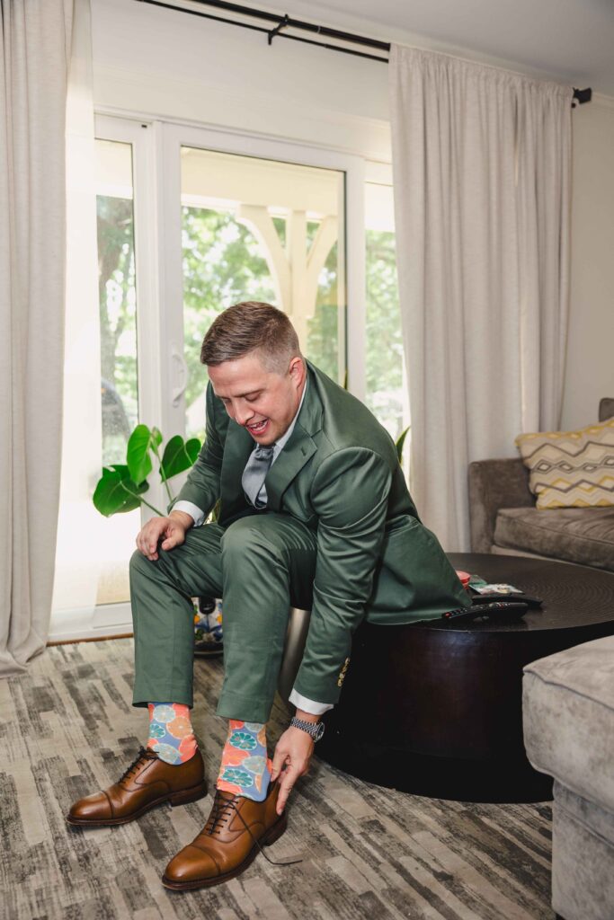 Groom putting on his shoes while wearing fun socks