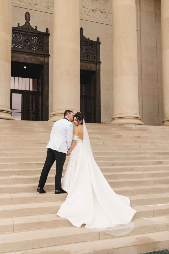 The bride and groom posing on the steps at Nelson Atkins in Kansas City.