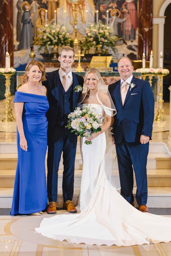 Bride and groom with their parents from their wedding family photos list 