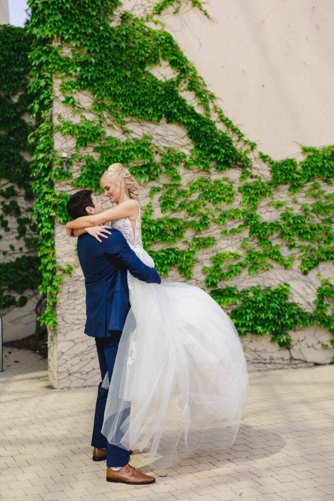 Groom holding his wife as they look into each others eyes.