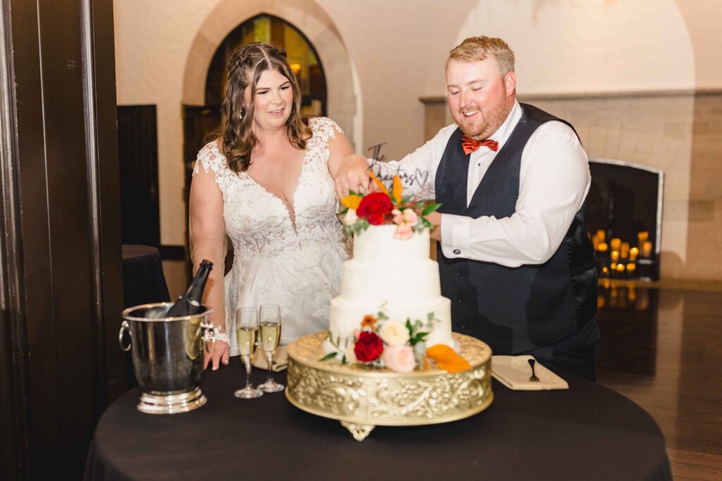 Newlyweds cutting cake together. 