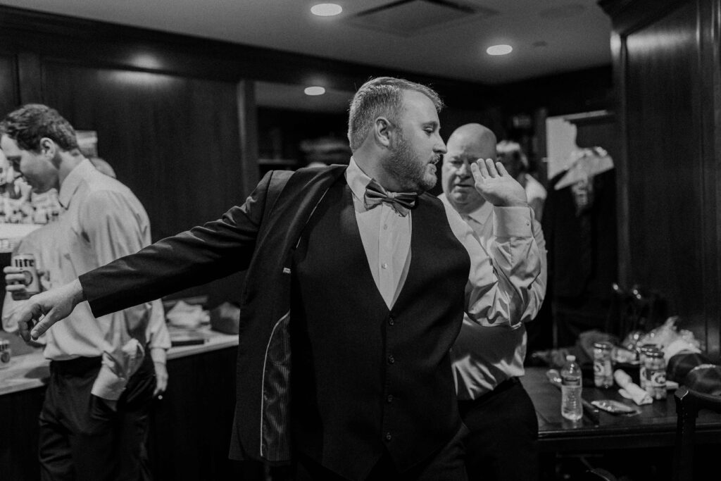 Groom putting on his suit jacket before his Oakwood Country Club wedding. 