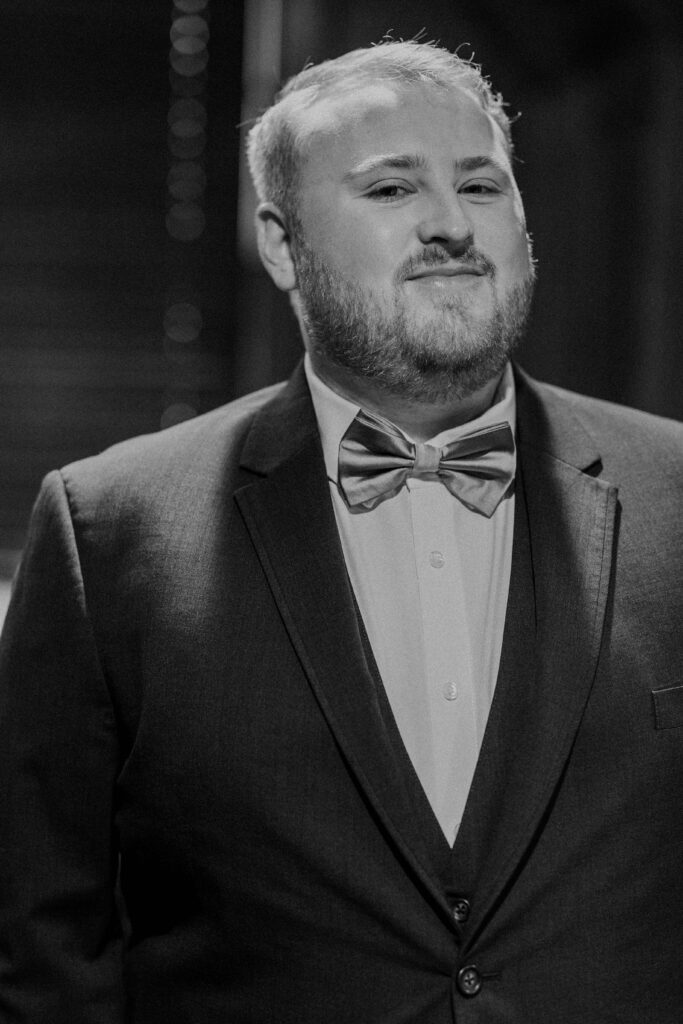 Groom smiling after putting on his wedding suit. 