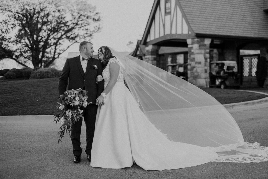 Newlyweds looking into each others eyes as the bride's veil flows in the wind. 