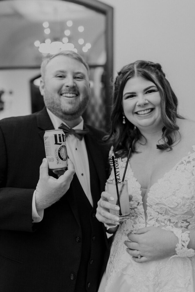 Bride and groom smiling holding their favorite drinks. 