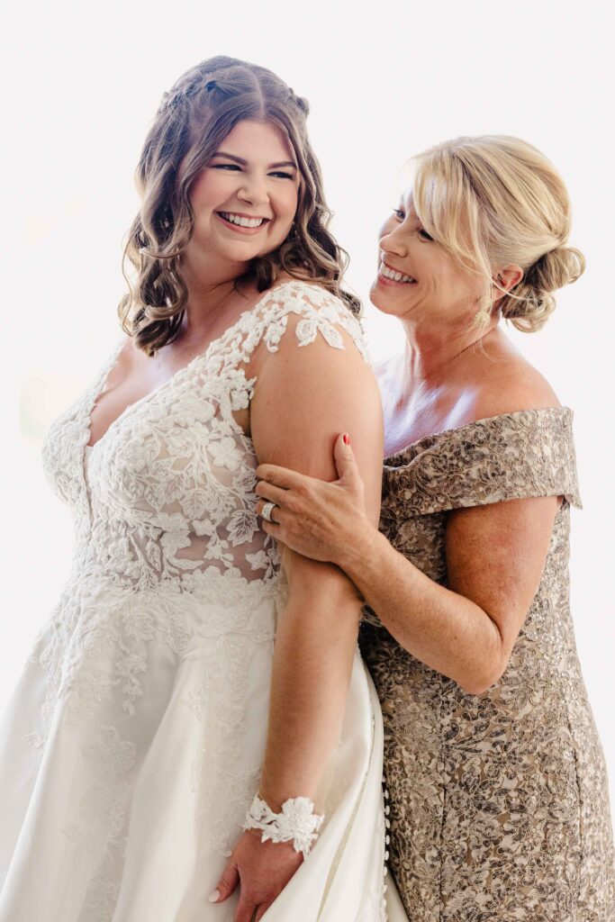 Bride and her mother smiling after getting ready.