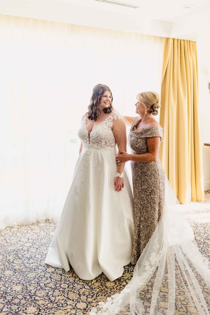 Mom helping the bride get in her wedding dress. 