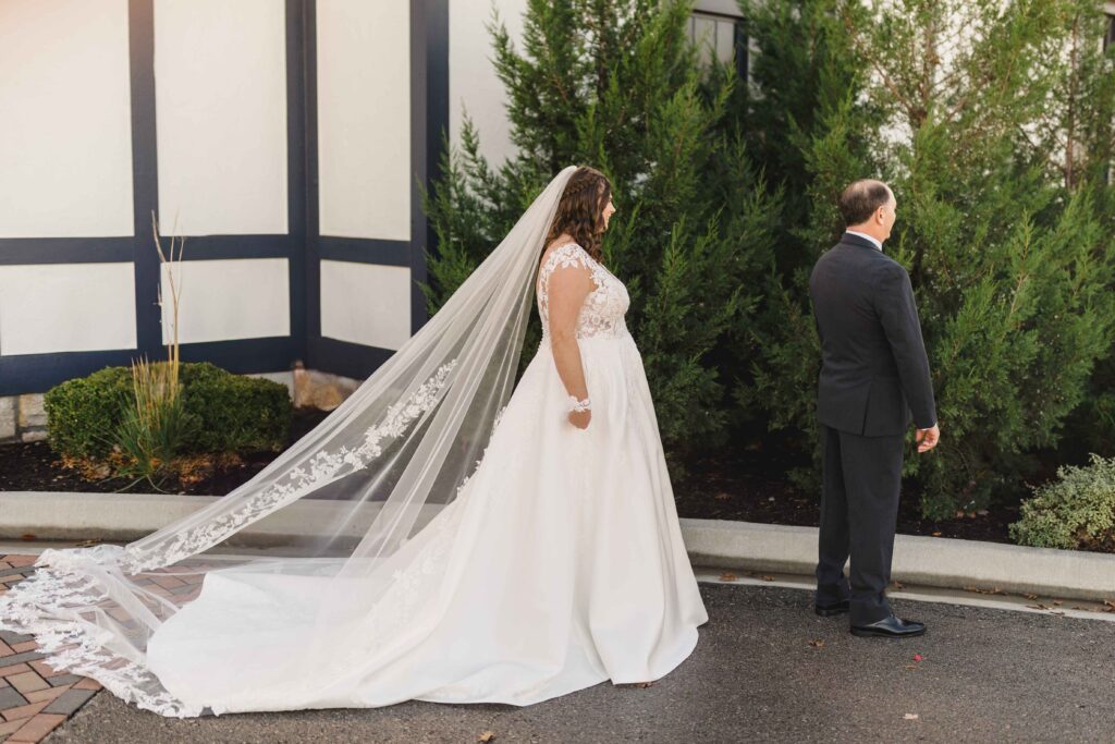 Bride standing behind her dad before a first look. 