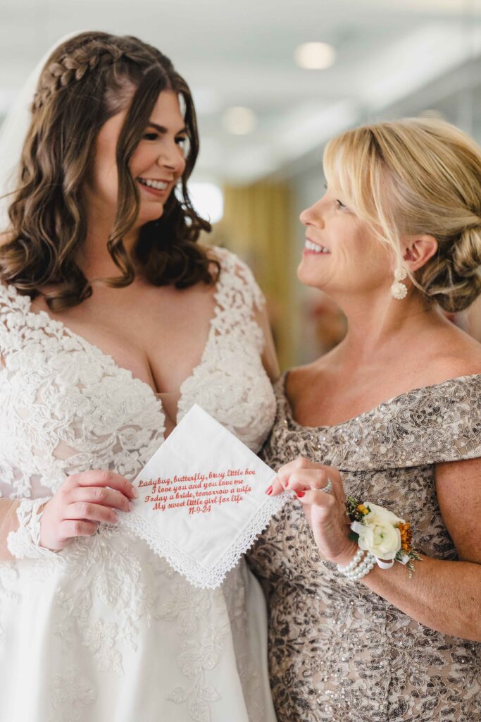 Bride and her mom holding a sweet gift from her mom. 